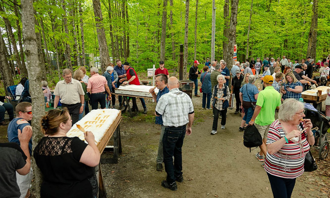 Les festivaliers mangent de la tire pendant la partie de sucre du Festival des Sucres de Saint-Pierre-Baptiste