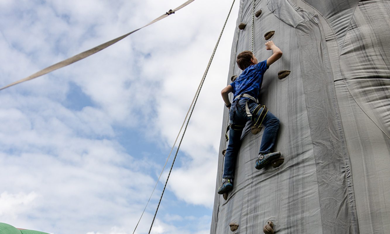 Un enfant fait de l'escalade sur un mur gonflable pendant le Festival des Sucres de Saint-Pierre-Baptiste