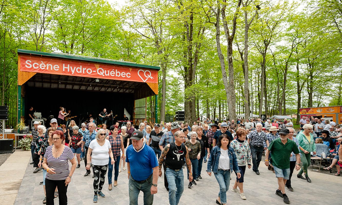 Des danseurs font de la danse en ligne en plein coeur de la forêt pendant le Festival des Sucres de Saint-Pierre-Baptiste