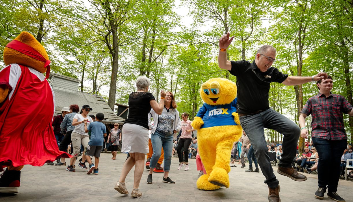 Une mascotte danse avec les participants au Festival des Sucres de Saint-Pierre-Baptiste